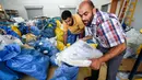 Pekerja pos Palestina memilah karung berisi surat yang sebelumnya diblokade Israel sejak tahun 2010 di kota Jericho, Tepi Barat, 14 Agustus 2018. Seorang pejabat mengatakan diperlukan dua minggu lagi untuk menyortir dan mengirimkannya. (AFP/ABBAS MOMANI)