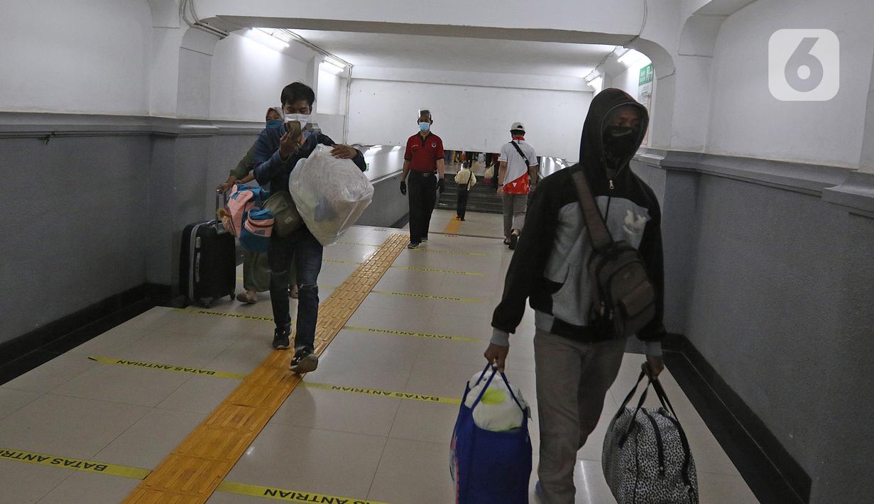 Penumpang kereta api Dharmawangsa Surabaya Pasarturi–Pasar Senen tiba di stasiun Senen, Jakarta, Minggu (3/01/2021). Hingga pagi, sudah ada 16.374 penumpang tiba di Stasiun Daop 1 Jakarta. (Liputan6.com/Herman Zakharia)