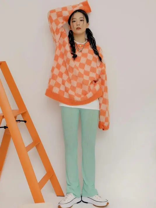 Tampilan streetwear yang chic, bisa tiru gaya Seulgi Red Velvet berikut ini. Padukan sweater motif checkered warna peach dengan celana warna tosca. Kece! (Instagram/hi_sseulgi).