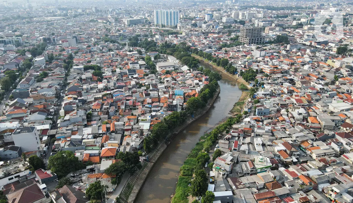 Aliran Sungai Ciliwung mengalir di antara permukiman warga di kawasan Bidara Cina, Jakarta, Rabu (28/6/2023). (Liputan6.com/Herman Zakharia)