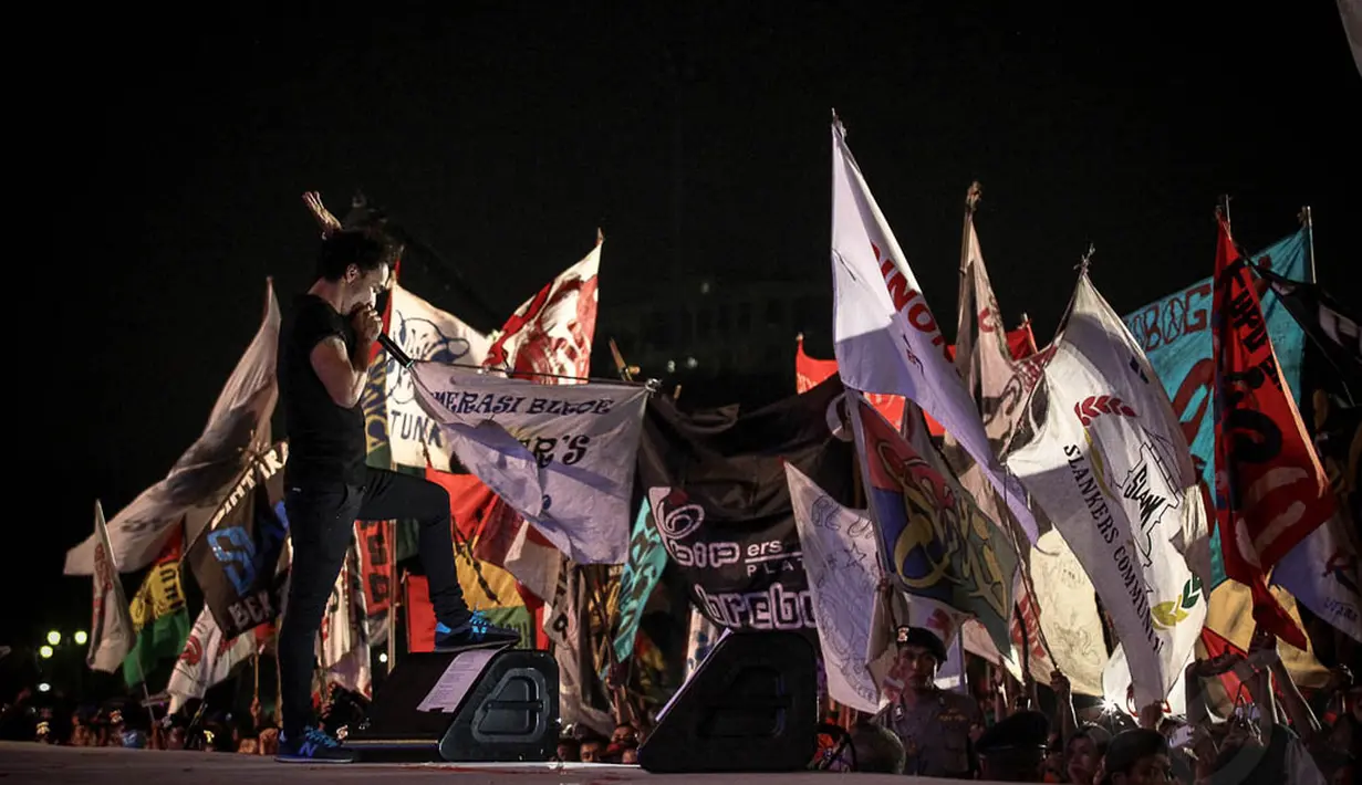 Ratusan penonton konser Syukuran Rakyat Salam 3 Jari mengibarkan bendera atribut di kawasan Monas, Senin (20/10), Jakarta, (20/10/14). (Liputan6.com/Faizal Fanani)