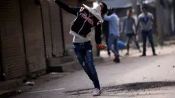 Demonstran melempar batu saat aksi di Srinagar, India, Selasa (13/9). Mereka protes karena pembunuhan yang terjadi di Kashmir belum lama ini. (REUTERS / Danish Ismail)