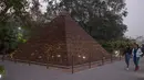 Pengunjung memandang replika Piramida Agung Giza di sebuah taman umum di New Delhi, 4 Februari 2020. Barang-barang bekas seperti besi batangan, suku cadang mobil, dan pipa dimanfaatkan untuk membuat tujuh keajaiban dunia yang ikonis di taman umum itu dan menarik banyak pengunjung. (Xinhua/Javed Dar)