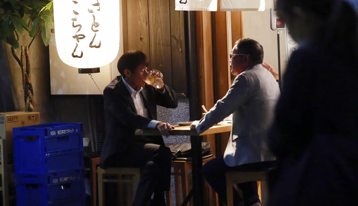 Orang-orang menikmati minuman di sebuah bar di Tokyo, Jepang, 4 Oktober 2021. Warga kembali beraktivitas setelah berakhirnya status pembatasan darurat virus corona COVID-19 di Jepang. (AP Photo/Koji Sasahara)