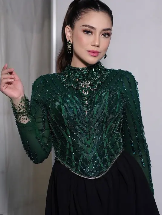 Celine Evangelista juga didapuk menjadi pembawa acara di malam tahun baru. Ia tampil mengenakan atasan hijau emerald dihiasi beads dipadukan rok panjang hitam. [@loritayoung_mua]
