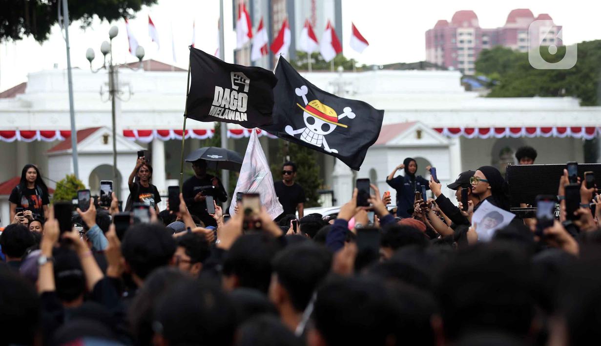 Peserta aksi Jaringan Solidaritas Korban untuk Keadilan mengibarkan bendera anime One Piece saat mengikuti peringatan 19 tahun Aksi Kamisan di Jalan Medan Merdeka Utara atau di seberang Istana Merdeka, Jakarta, 15 Januari 2026. (Liputan6.com/Helmi Fithriansyah)