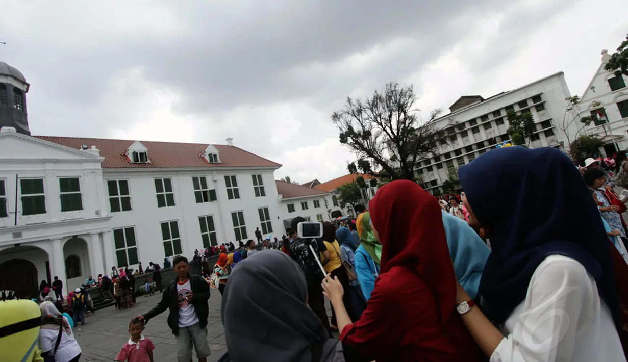 Kawasan Kota Tua Jakarta masih menjadi lokasi wisata favorit warga Jakarta, Jumat (26/12/2014). Sejumlah pengunjung berfoto bersama di kawasan Kota Tua Jakarta. (Liputan6.com/Faizal Fanani)