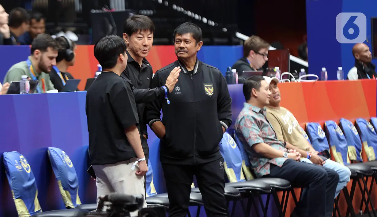 Pelatih timnas senior dan U-23 Indonesia, Shin Tae-yong (tengah) bersama Indra Sjafri saat menyaksikan laga penutup penyisihan grup H FIBA World Cup 2023 antara Latvia dan Kanada di Indonesia Arena, Gelora Bung Karno, Jakarta, Selasa (29/8/2023). (Liputan6.com/Helmi Fithriansyah)