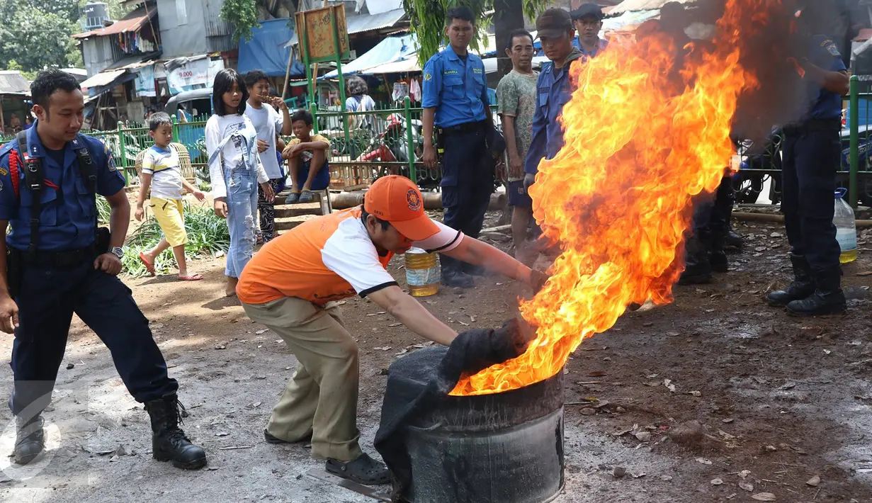 Petugas pemadam kebakaran mensosialisasikan cara pemadaman api kepada warga di kawasan Manggarai, Jakarta, Minggu (9/10). Sosialisasi yang disampaikan tentang cara penggunaan proteksi dan pecegahan pertama pada kebakaran. (Liputan6.com/Immanuel Antonius)
