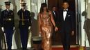 Kemesraan Presiden AS Barack Obama dan Michelle Obama saat menunggu kedatangan PM Italia Matteo Renzi dan Agnese Landini di Gedung Putih, Washington, Selasa (18/10). Malam itu, Michelle tampil cantik berbalut gaun rancangan Versace. (Nicholas Kamm/AFP)