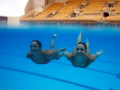 Atlet renang indah Brasil, Maria Eduarda Miccuci (kanan) dan Luisa Borges beraksi dalam sesi foto jelang Olimpiade Rio 2016 di Rio Olympic Park, Rio de Janeiro, Brasil, (Reuters/Pilar Olivares)