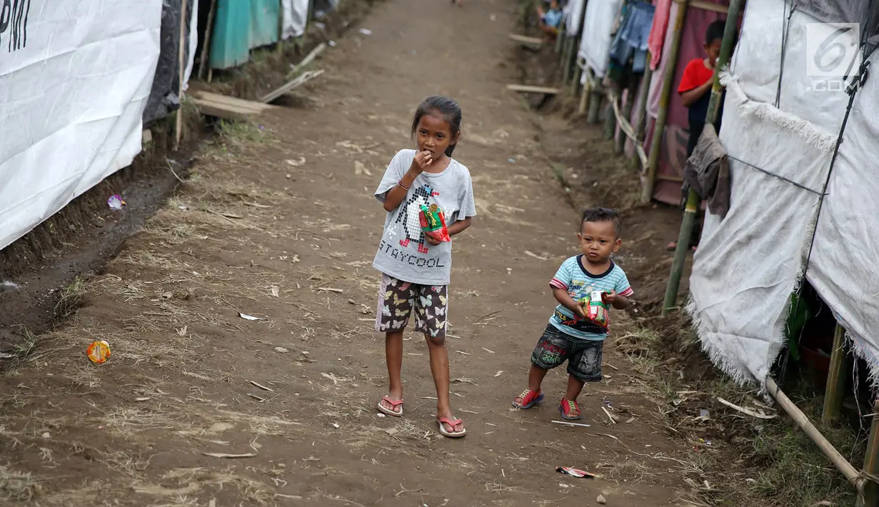 Anak-anak bermain di sekitar tenda Posko Pengungsi Rendang, Bali, Sabtu (2/12). Erupsi Gunung Agung membuat anak-anak tersebut terpaksa harus bermain di posko pengungsian dengan kondisi yang seadanya. (Liputan6.com/Immanuel Antonius)