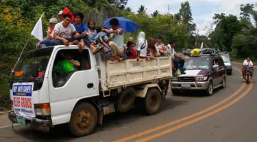 Sejumlah mobil membawa warga Marawi yang menyelamatkan diri dari pertempuran antara pasukan pemerintah dengan kelompok Maute, Filipina, Senin (29/5). Bendera putih dipasang agar mereka tidak diserang oleh pasukan pemerintah. (AP Photo / Bullit Marquez)