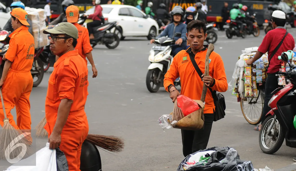 Dengan membawa alat-alat kebersihan, mereka menyisir jalanan, trotoar dan taman-taman yang ada di tengah jalan di Silang Tenggara Monas, Jakarta, Jumat (14/10). (Liputan6.com/Helmi Fithriansyah)