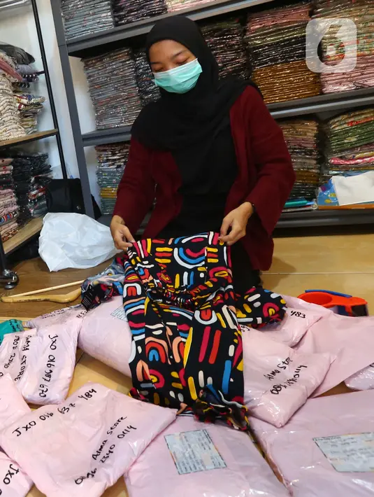 Pedagang mengemas baju pelanggan untuk pesanan online di salah satu outlet pakaian di Kawasan Tangerang, Banten, Rabu (9/2/2022). Badan Pusat Statistik (BPS) meyakini daya beli masyarakat makin membaik pada awal tahun 2022. (Liputan6.com/Angga Yuniar)