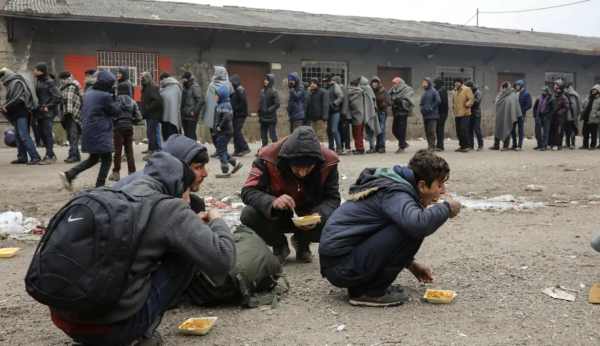 Sejumlah imigran mengantre untuk mendapatkan makanan di gudang tak terpakai di Belgrade, Serbia, Kamis (22/12). (REUTERS / Marko Djurica)