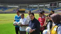 Ketua PSSI, Erick Thohir, menyerahkan souvenir Piala Dunia U-20 2023 kepada Wali Kota Solo, Gibran Rakabuming Raka, saat mengunjungi Stadion Manahan, Minggu (12/3/2023). (Bola.com/Radifa Arsa)
