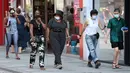 Orang-orang memakai masker saat berjalan di Brussel, Belgia, Rabu (12/8/2020). Penggunaan masker menjadi wajib di tempat umum di Brussel karena kasus Covid-19 naik ke tingkat kewaspadaan yang menempatkan kota itu di antara yang paling parah terkena dampak corona di Eropa. (François WALSCHAERTS/AFP)