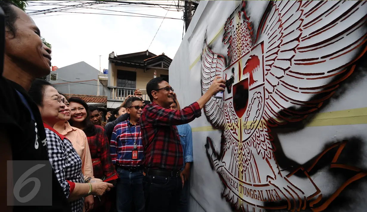 Presiden ke-5 RI Megawati Soekarnoputri menyaksikan Cawagub DKI Djarot Saiful Hidayat mewarnai mural bergambar Garuda Pancasila di dinding TPS tempatnya, di TPS 027 Kebagusan, Jakarta Selatan, Rabu (15/2). (Liputan6.com/Helmi Fithriansyah)