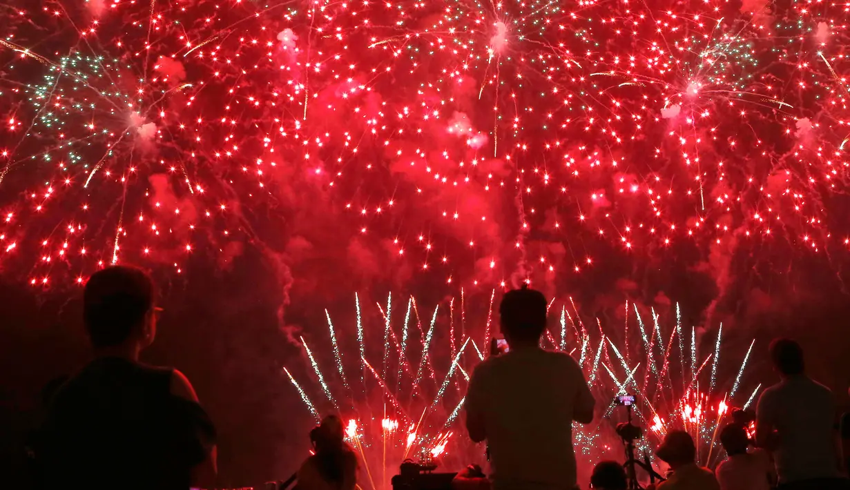 Penonton menyaksikan pertunjukan kembang api dari Pandora-Pyrotechnie asal Perancis pada Kompetisi Pyromusical Internasional di Manila, Filipina, Sabtu (10/3). Acara yang menarik ribuan wisatawan ini sudah memasuki tahun ke-9. (AP/Bullit Marquez)