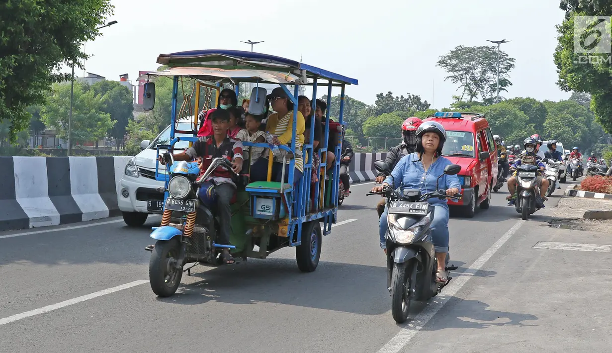 Sejumlah warga menaiki bak terbuka motor roda tiga menuju Kebun Binatang Ragunan di kawasan Jakarta, Minggu (9/6/2019). Selain melanggar aturan lalu lintas, perilaku tersebut juga sangat membahayakan keselamatan penumpang. (Liputan6.com/Herman Zakharia)