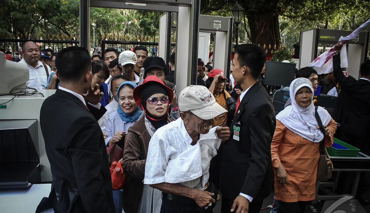 Seorang kakek tersenyun sumringah diperbolehkan masuk oleh petugas ke Istana negara usai menjalani pemeriksaan, Jakarta, Senin (20/10/2014) (Liputan6.com/Faizal Fanani)