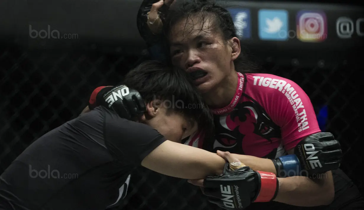 Petarung Cina, Xiong Jing Nan, mendorong petarung Singapura, Tiffany Teo, saat laga One Championship di JCC Senayan, Jakarta, Sabtu (20/1/2018). Jing Nan berhasil merebut juara dunia kelas jerami. (Bola.com/Vitalis Yogi Trisna)