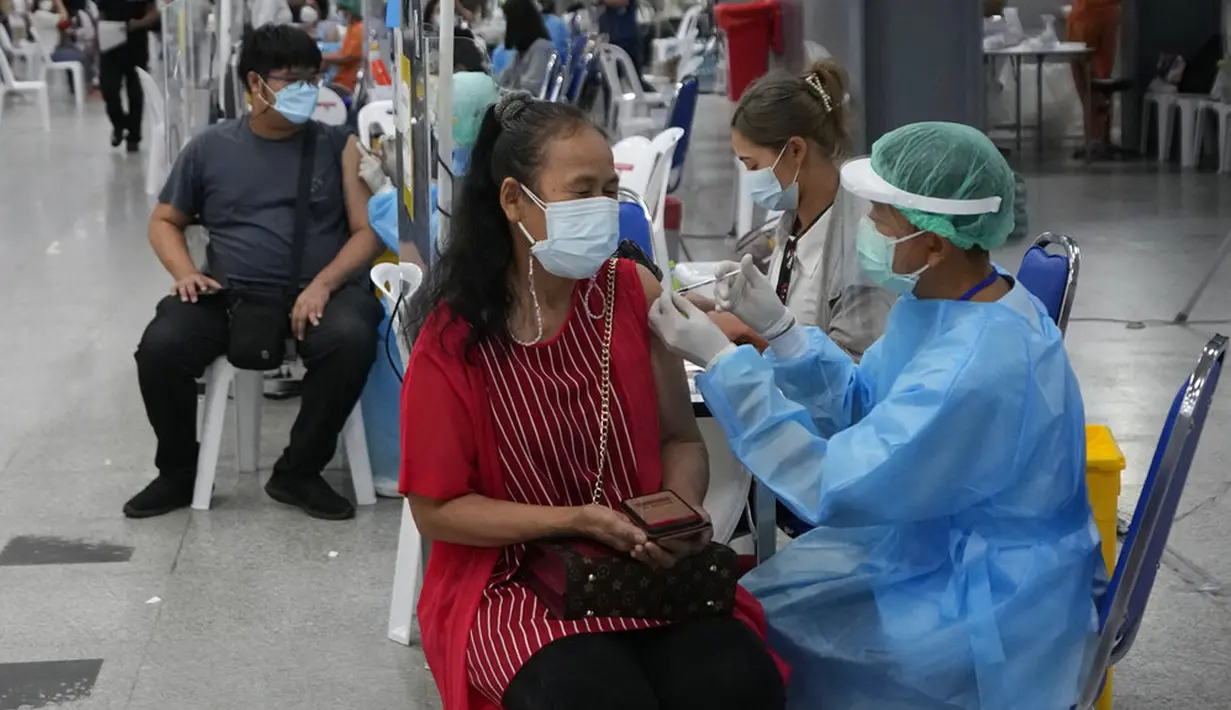 Seorang petugas kesehatan menyuntikkan dosis vaksin COVID-19 Pfizer kepada warga di pusat vaksinasi di Bangkok, Thailand, Jumat (4/2/2022). (AP Photo/Sakchai Lalit)