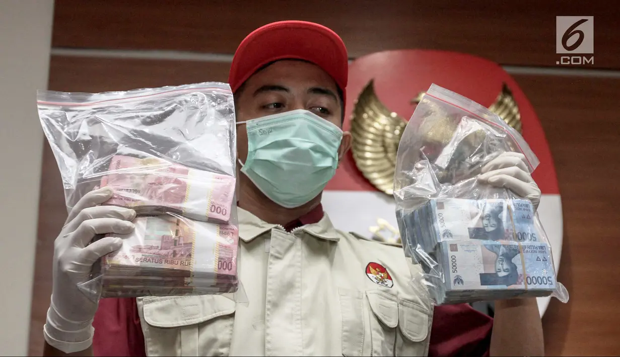 Petugas KPK menunjukkan barang bukti hasil OTT di gedung KPK, Jakarta, Jumat (5/1). KPK menetapkan empat orang sebagai tersangka dalam kasus dugaan suap proyek pengadaan pekerjaan pembangunan RSUD Damanhuri, Barabai. (Liputan6.com/Faizal Fanani)