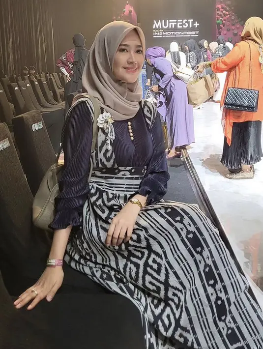 Ia pun hadir di muffest mengenakan dress lengan panhan plisket dengan detail overall panjang motif kain khas nusantara. Credit: (@lisyanurrahmii)