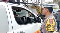 Petugas Satuan Lalu Lintas Polres Bogor menindak satu unit mobil ambulans lantaran melawan arus di jalur Puncak, Bogor, Jumat (23/12/2022) pagi. (Liputan6.com/Achmad Sudarno)