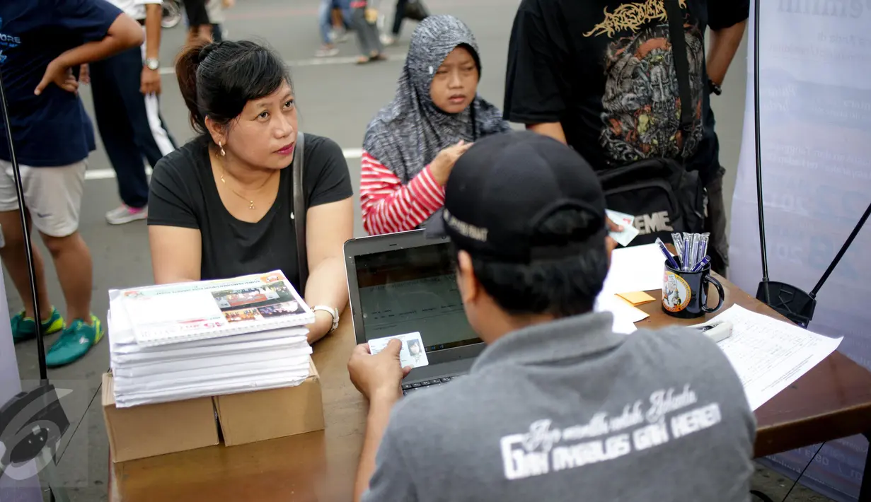 Warga mendaftarkan namanya di posko KPUD DKI di kawasan Bundaran HI, Jakarta, Minggu (26/3). KPUD Jakarta membuka posko pemeriksaan data pemilih terdaftar untuk Pilkada DKI 2017 putaran kedua. (Liputan6.com/Faizal Fanani)