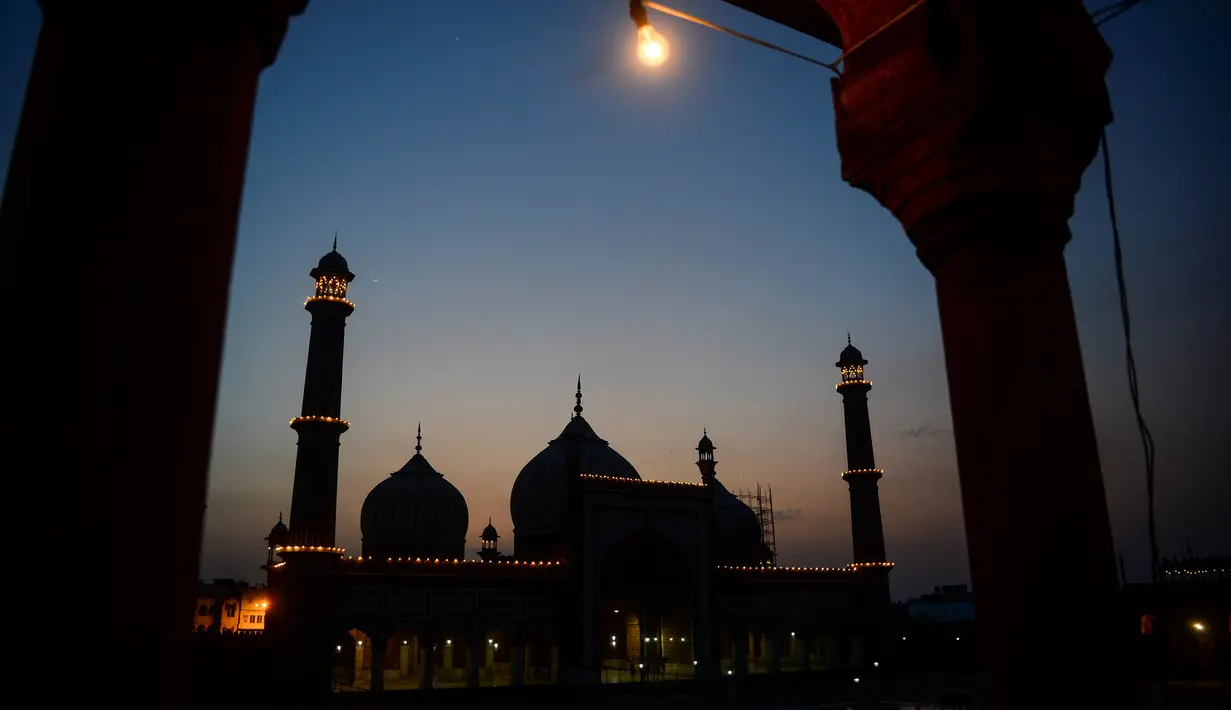 Masjid Jama diterangi cahaya pada bulan suci Ramadan di bawah penerapan lockdown untuk menekan penyebaran virus corona di New Delhi , 25 April 2020. Masjid terbesar di India itu selalu ramai dipenuhi orang-orang saat datangnya Ramadan namun, kini terlihat sepi imbas Covid-19. (Sajjad HUSSAIN/AFP)