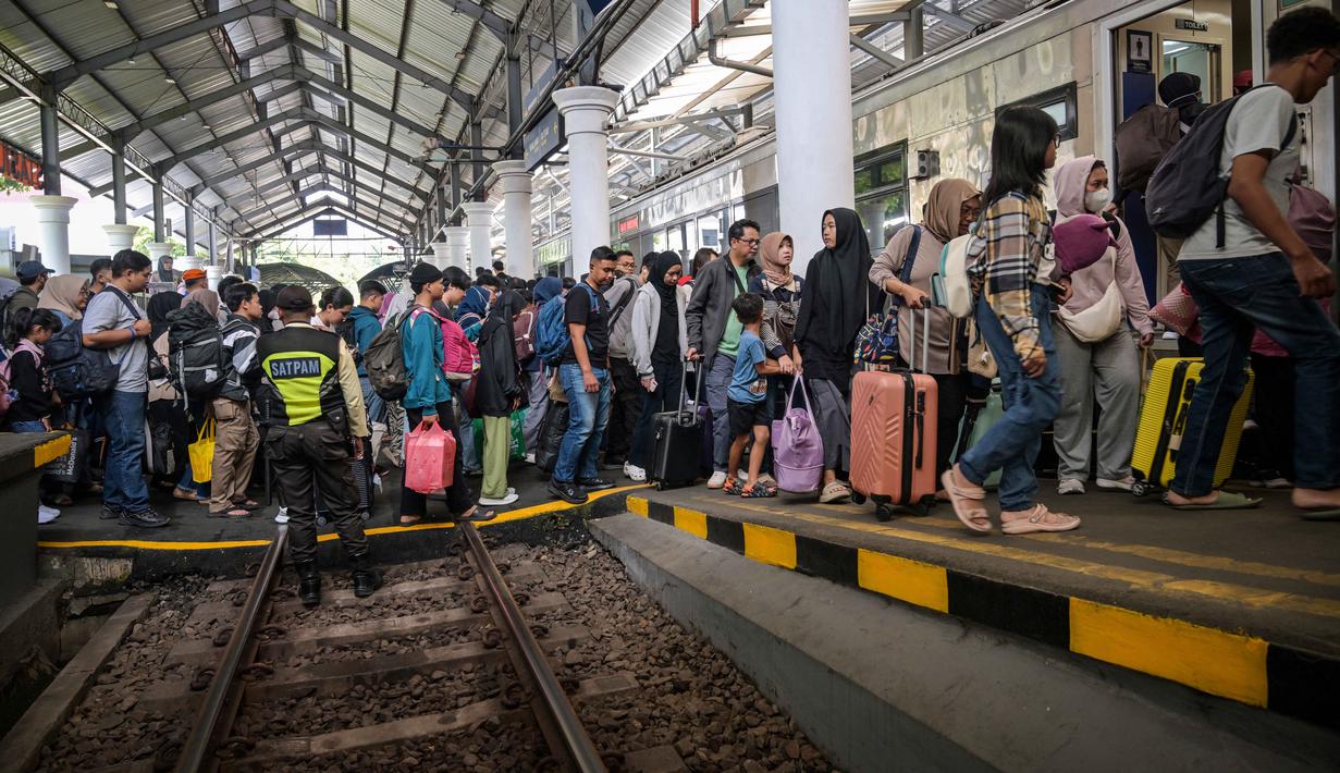 Sementara itu, hingga Selasa (17/3/2026), lebih dari 393 ribu tiket kereta api jarak jauh telah ludes terjual. Tampak dalam foto, para penumpang menaiki kereta di stasiun Gubeng, Surabaya, Jawa Timur, Selasa 17 Maret 2026. (JUNI KRISWANTO/AFP)