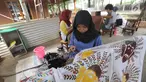Perajin membuat batik tulis khas Betawi di rumah produksi Keluarga Batik Betawi, Setu Babakan, Jakarta Selatan, Minggu (10/3). Batik Betawi ini bermotif ondel-ondel, bunga manggar hingga Monumen Nasional (Monas). (merdeka.com/Arie Basuki)