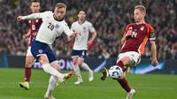 Pemain Inggris, Jarrod Bowen, melepaskan tendangan tanpa mampu diadang bek Latvia, Andrejs Ciganiks, dalam lanjutan Kualifikasi Piala Dunia 2026 Zona Eropa, Selasa (25/3/2025) dini hari WIB. (Glyn KIRK / AFP)