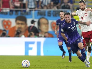Pemain Argentina Alexis Mac Allister (kiri) berebut bola dengan pemain Polandia Grzegorz Krychowiak selama pertandingan sepak bola grup C Piala Dunia 2022 di Stadion 974, Doha, Qatar, Rabu (30/11/2022). Dalam pertandingan melawan Polandia, Argentina lebih unggul dua skor dari tim asuhan Czeslaw Michniewicz tersebut. (AP Photo/Darko Bandic)