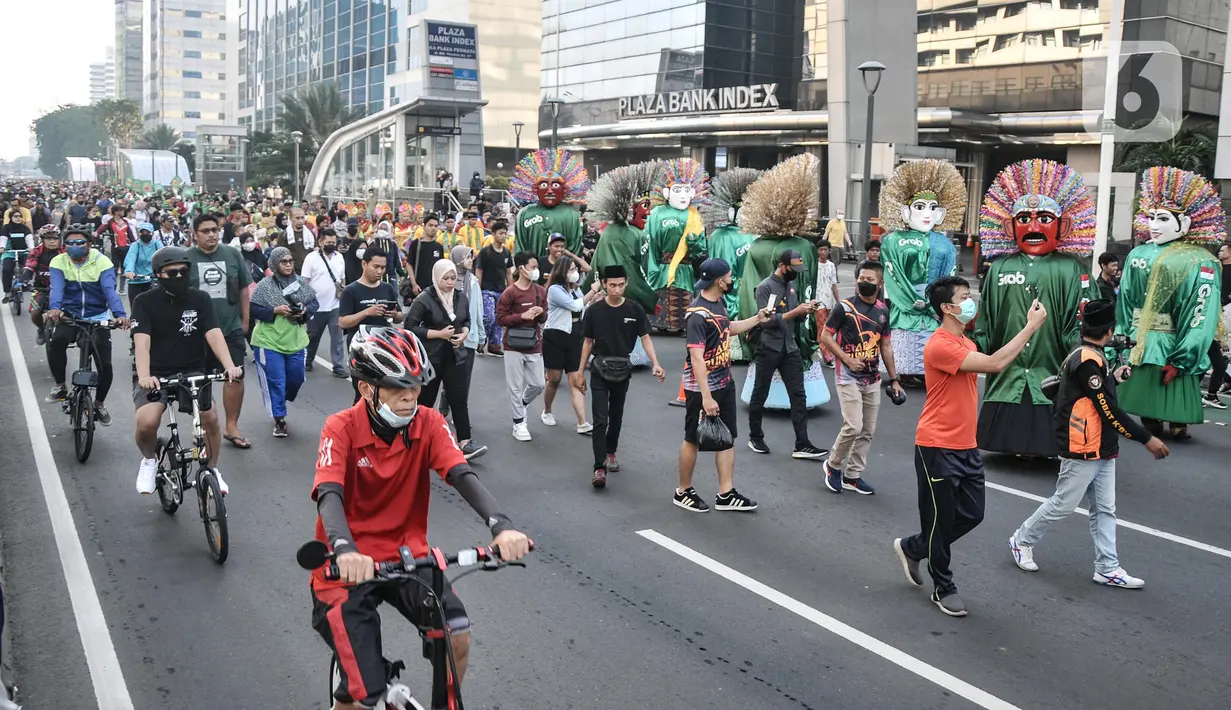 Ondel-ondel tampil dalam pawai budaya dan kesenian Betawi saat Hari Bebas Kendaraan Bermotor (HBKB) atau car free day (CFD) di Jalan MH Thamrin, Jakarta, Minggu (19/6/2022). Pawai yang menampilkan berbagai budaya dan kesenian Betawi seperti ondel-ondel, tari topeng, serta tanjidor tersebut digelar dalam rangka menyambut HUT ke-495 DKI Jakarta. (merdeka.com/Iqbal S. Nugroho)