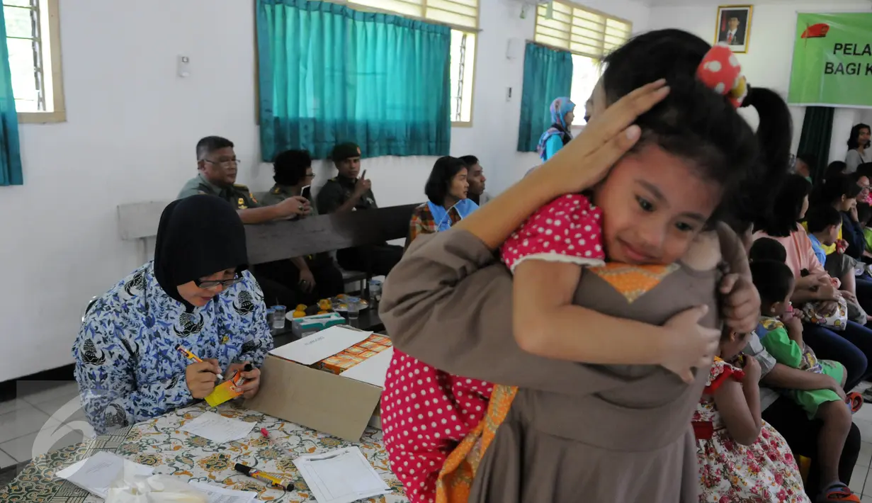 Seorang anak anggota TNI digendong ibunya usai mengikuti vaksinasi ulang di Kantor Kesehatan Kopassus Jakarta, Senin (18/7). Kopassus menggelar vaksinasi ulang terhadap anak prajurit yang terindikasi menjadi korban vaksin palsu (Liputan6.com/Helmi Afandi)