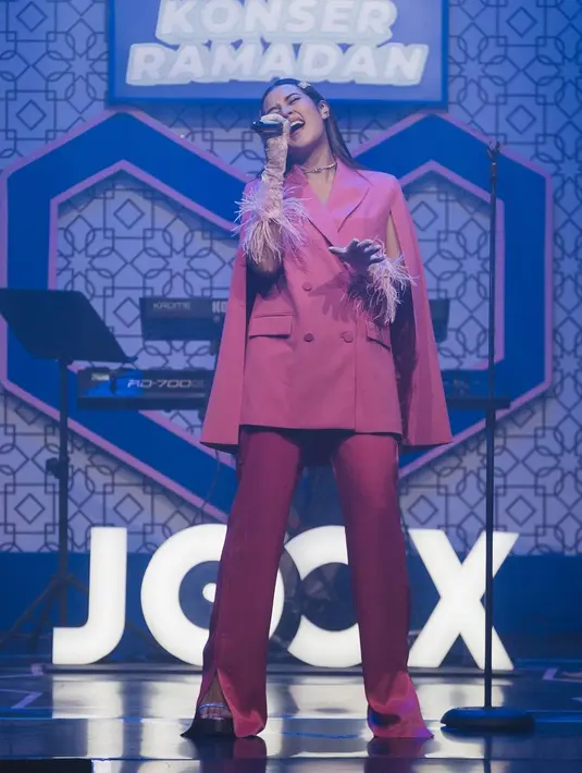 <p>Masih dengan palet warna monokrom, Raisa tampil dengan oversized double-breasted blazer berwarna magenta, detail cape di bagian lengan, dipadunya mengenakan satin trousers bernuasna senada. Ia menambahkan pemanis, gelang bulu di kedua tangannya. Foto: Instagram.</p>