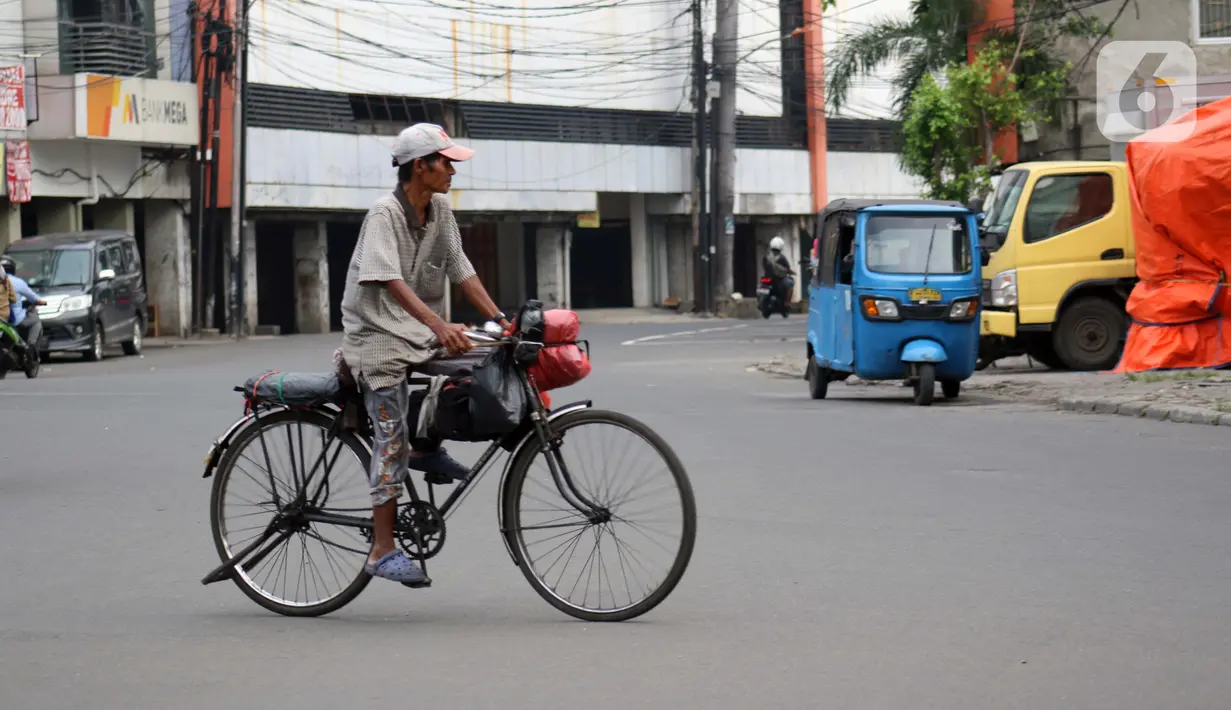 Pengojek sepeda mencari penumpang di kawasan Kota Tua, Jakarta, Selasa (21/4/2020). Penghentian sementara aktivitas sebagian besar pertokoan dan perkantoran seiring pelaksanaan WFH dan PSBB berimbas pada sulitnya pengojek sepeda mencari penumpang. (Liputan6.com/Helmi Fithriansyah)