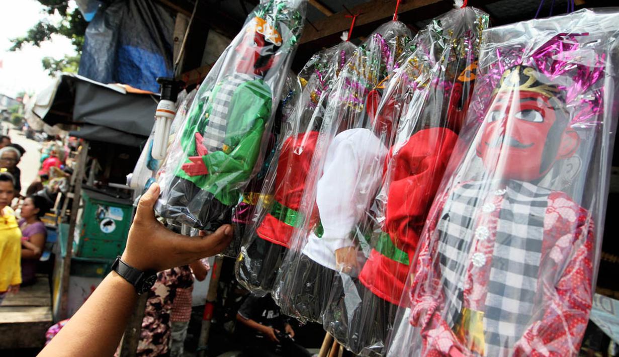 Pedagang menata miniatur ondel-ondel dagangannya di kawasan Kramat Pulo, Jakarta, Rabu (18/6/14). (Liputan6.com/Faizal Fanani)