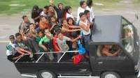 Sejumlah warga berpergian dengan menggunakan mobil bak terbuka di Jalan Raya Padang - Bukittinggi di Kab. Padangpariaman, Sumbar. (Antara)