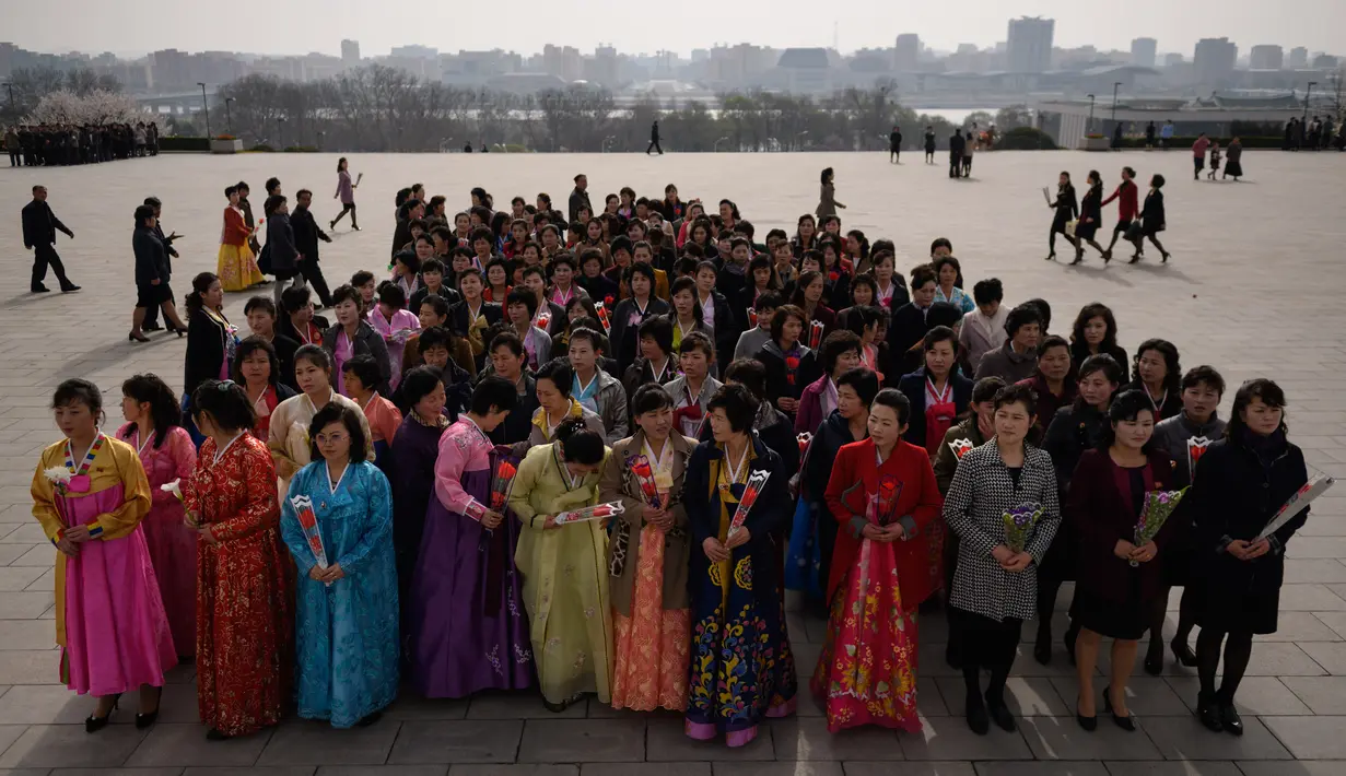 Sejumlah wanita memberi penghormatan kepada patung Kim Il Sung dan Kim Jong Il di Pyongyang (15/4). Kim Il Sung pernah menjabat sebagai perdana menteri pada tahun 1948-1972 dan presiden Korea Utara pada tahun 1972-1994. (AFP Photo/Ed Jones)