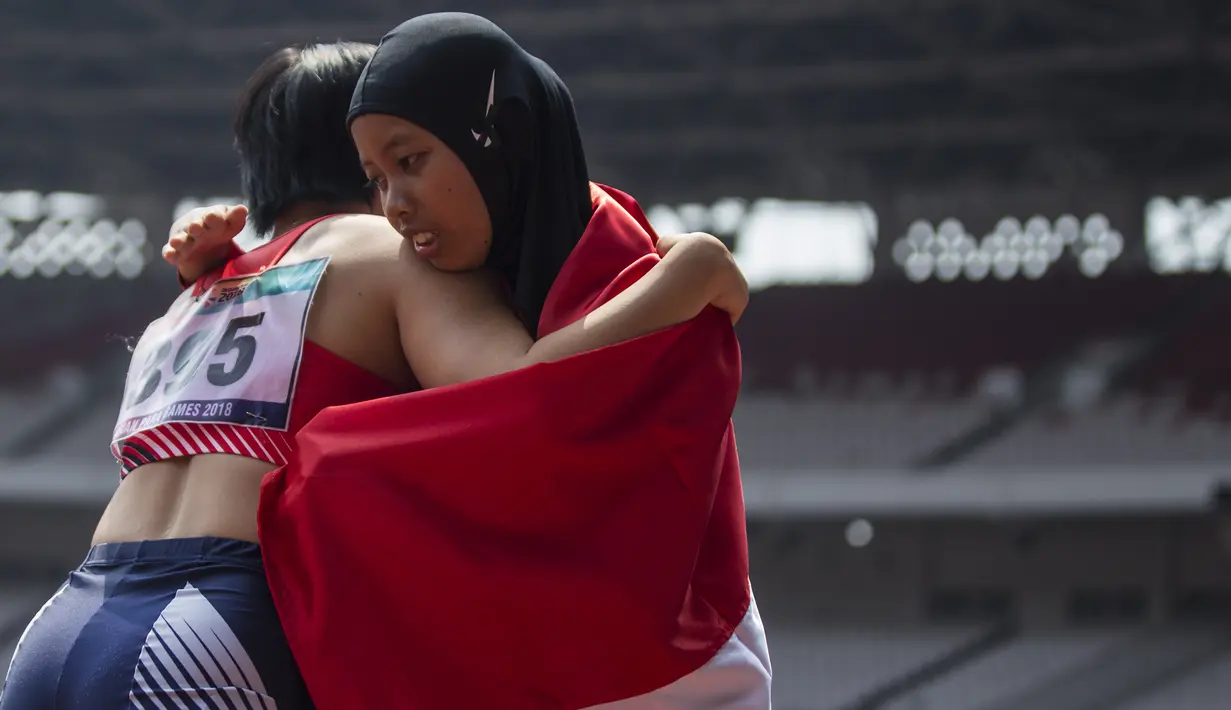 Pelari Indonesia, Tiarani Karisma, menghibur lawannya usai meraih medali emas Asian Para Games cabang atletik nomor lari 100 meter T42 / T63 di SUGBK, Jakarta, Rabu (10/10/2018). (Bola.com/Vitalis Yogi Trisna)