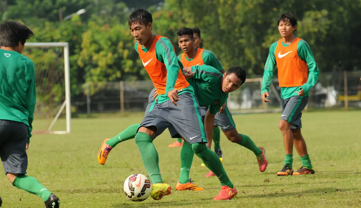 Bek timnas Indonesia U-23, Hansamu Yama Pranata (kedua kiri) berusaha mengecoh rekan setimnya saat berlatih di Lapangan Sutasoma, Jakarta, Rabu (25/3/2015). Garuda Muda akan berlaga di kualifikasi Grup H Piala Asia 2016. (Liputan6.com/Helmi Fithriansyah)