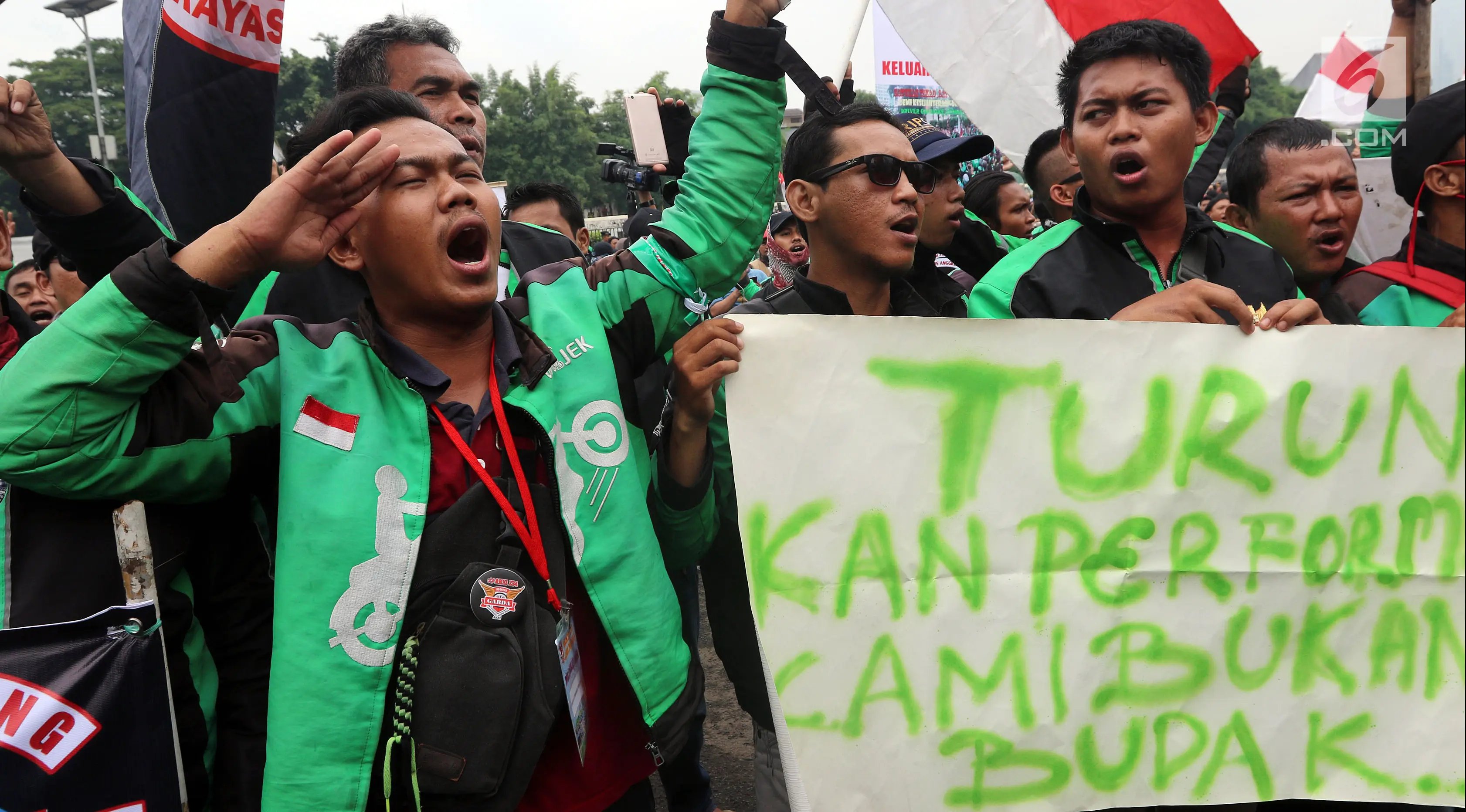 Pengemudi ojek online saat menggelar aksi unjuk rasa di depan Gedung MPR DPR, Jakarta, Senin (23/4). Aksi ini diikuti belasan ribu pengendara ojek online yang tergabung dalam Gabungan Aksi Roda Dua Indonesia (Garda). (Liputan6.com/Johan Tallo)