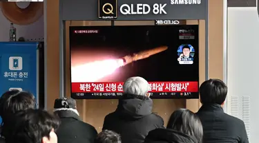 Orang-orang menonton layar televisi yang menampilkan siaran berita dengan file rekaman uji coba rudal Korea Utara, di sebuah stasiun kereta api di Seoul pada 28 Januari 2024. (Jung Yeon-je/AFP)