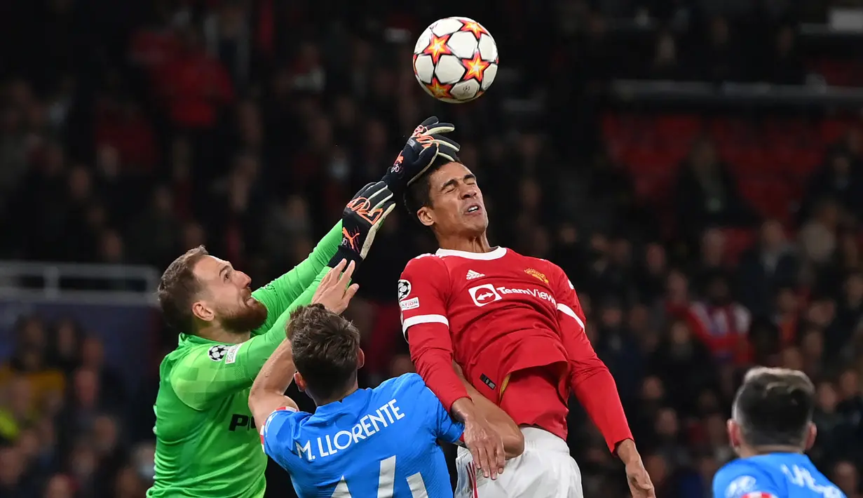 Bek Manchester United, Raphael Varane (kanan) berusaha menyundul bola di depan kiper Atletico Madrid, Jan Oblak dalam laga leg kedua babak 16 besar Liga Champions 2021/2022 di Old Trafford Stadium, Manchester (15/3/2022). Raphael Varane hingga kini telah bermain dalam 88 laga di Liga Champions bersama Real Madrid dan Manchester United dengan torehan 2 gol dan 2 assist. (AFP/Paul Ellis)