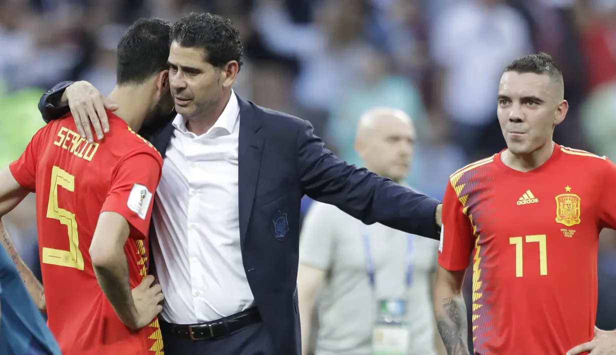 Pelatih Spanyol, Fernando Hierro memberikan semangat kepada Sergio Busquets (kiri) dan Iago Aspas usai kalah dari Rusia pada laga 16 besar Piala Dunia 2018 di Luzhniki Stadium, Moskow, Rusia, (1/7/2018). Spanyol kalah 3-4. (AP/Matthias Schrader)